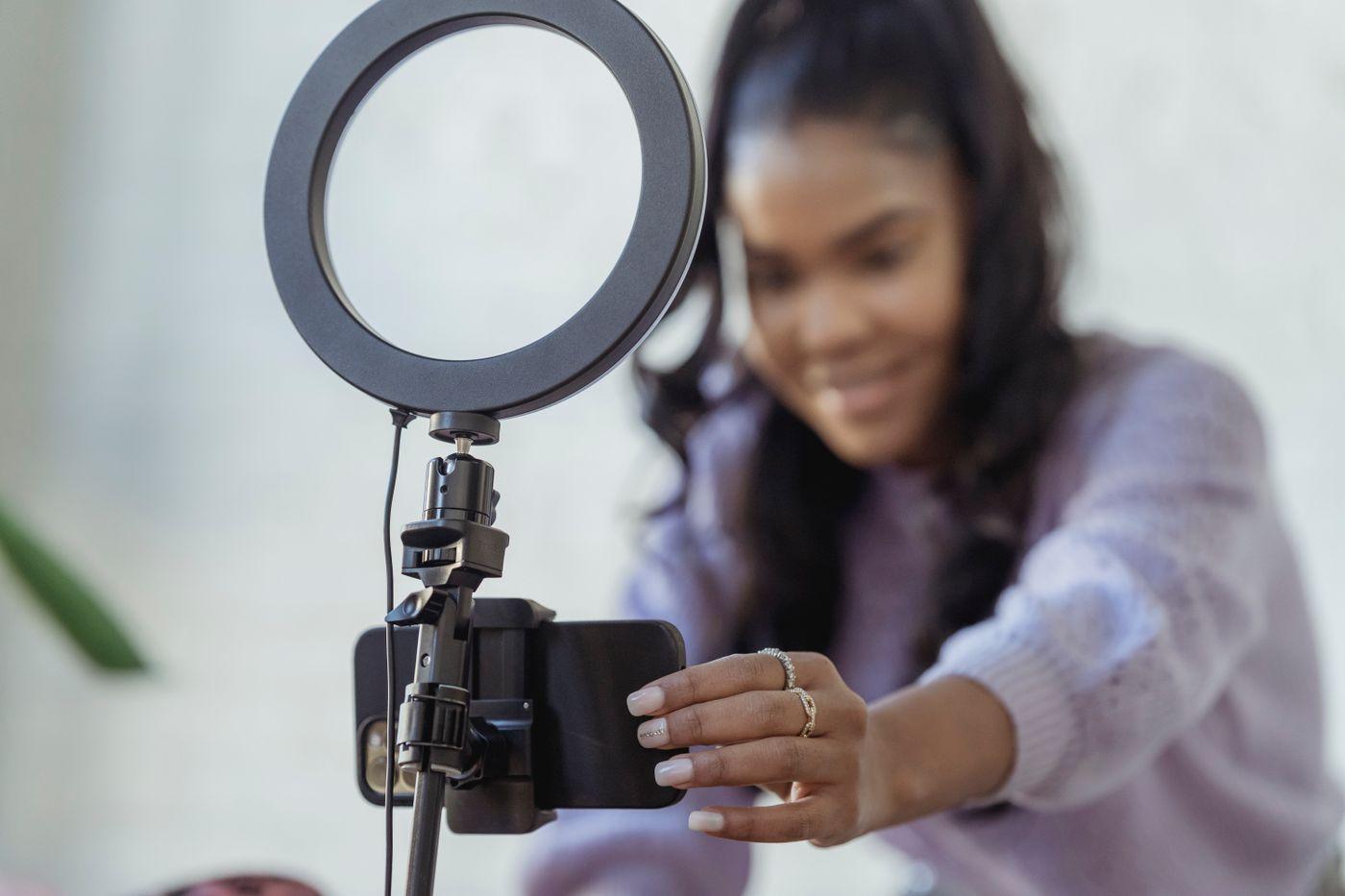 A creator setting up her smartphone to film content at home