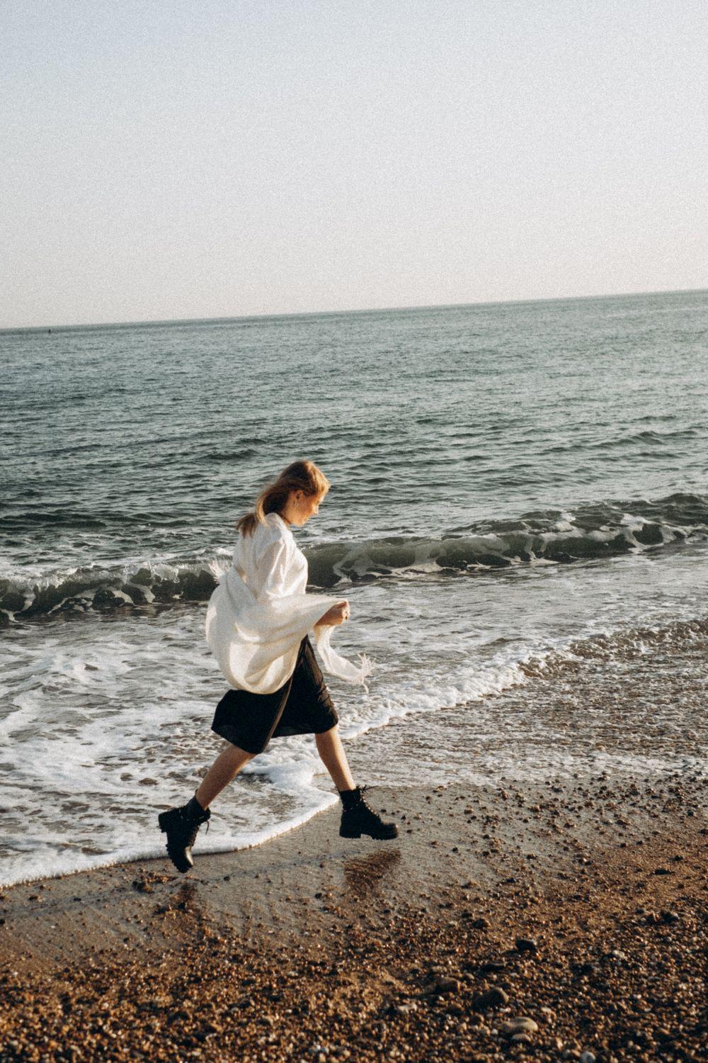 A traveller walking beside the waves on a quiet beach